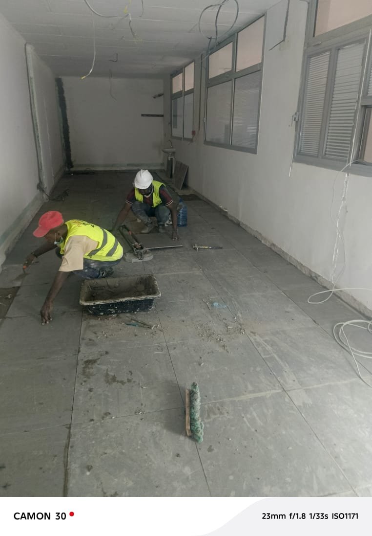Équipe PSG en travaux de finition et de reprise de sol dans un bâtiment à Port-Gentil