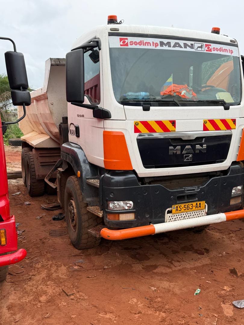 Camion benne MAN avec opérateur sur chantier industriel