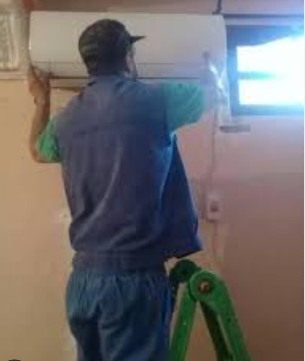 Technicien installant une unité intérieure de climatisation