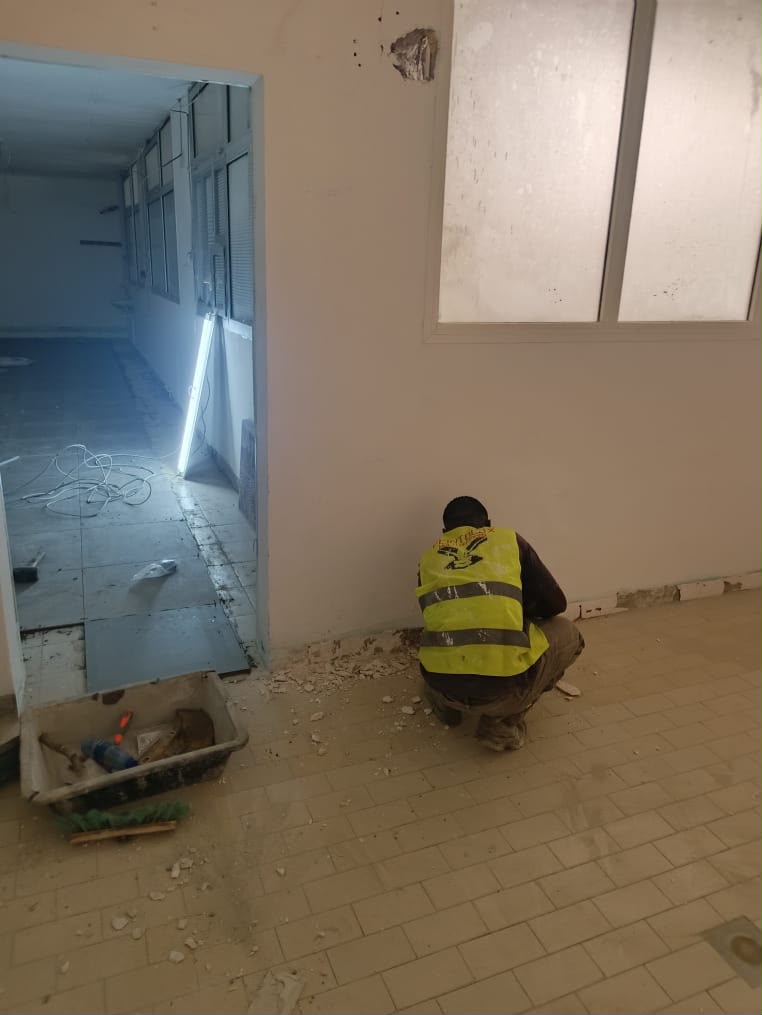 Technicien PSG en gilet de sécurité préparant un mur avant finition