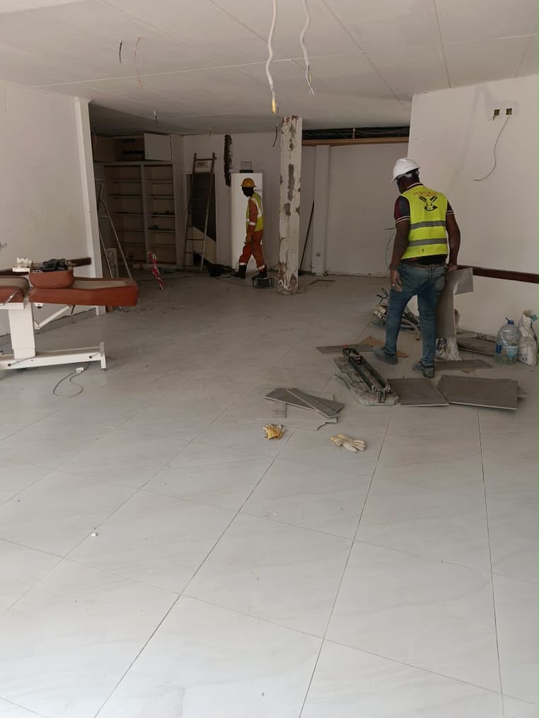 Équipe PSG posant du carrelage et préparant le sol d'un local professionnel