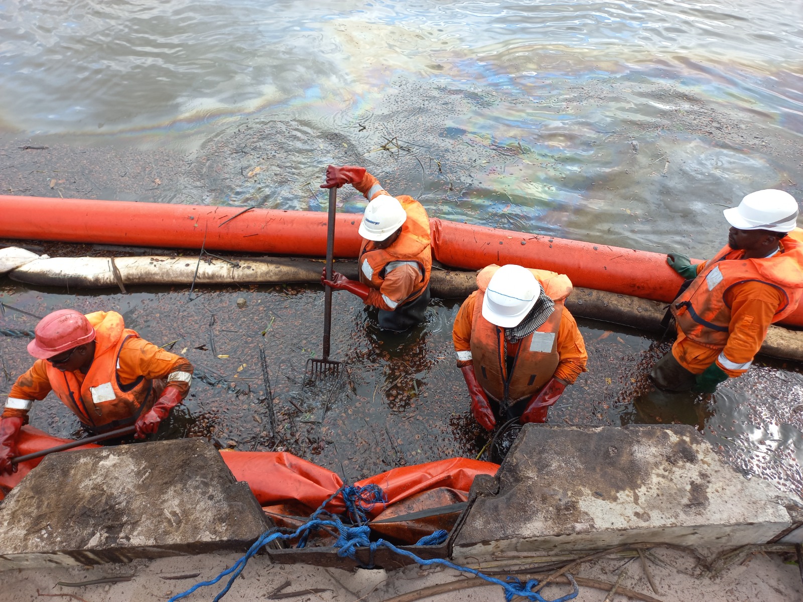 Agents PSG équipés intervenant dans l'eau avec un barrage flottant
